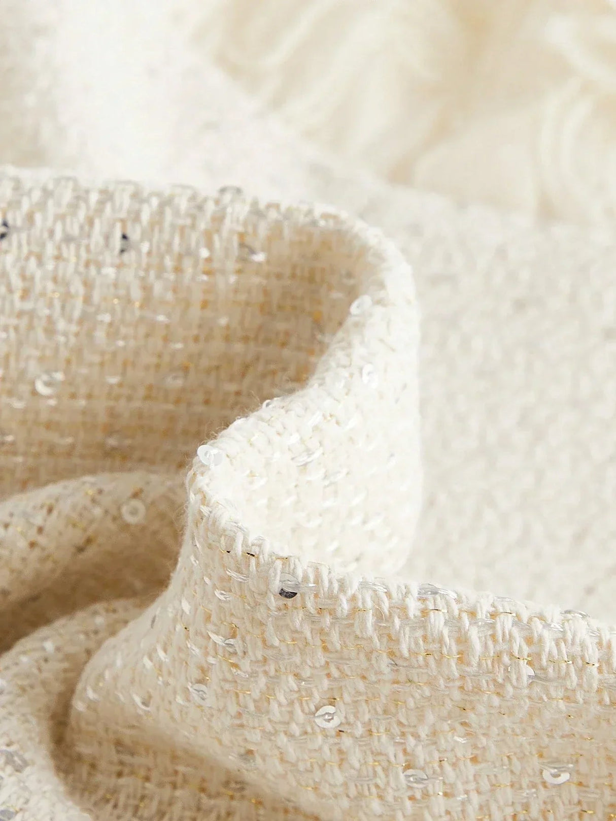 Crafted from a luxurious cream fabric, this elegant dress features a textured weave adorned with subtle sparkling sequins,.