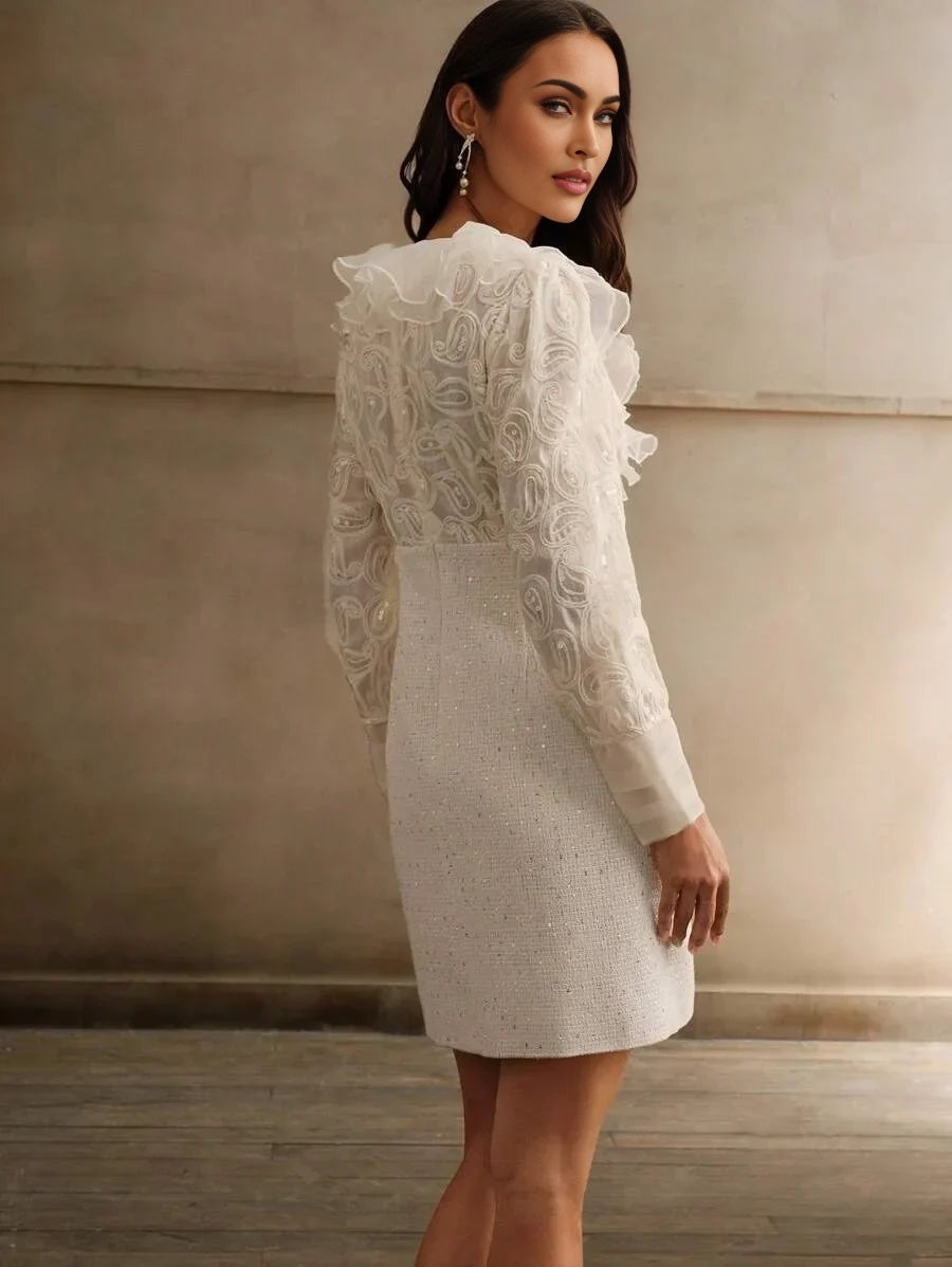 This stunning white dress features a fitted silhouette adorned with delicate ruffled detailing and floral textured sleeves,.