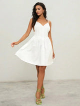 This charming white dress features a flattering A-line silhouette, complemented by delicate spaghetti straps and a deep.