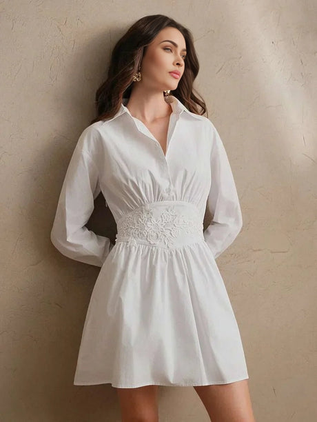 This chic white dress features a flattering fit-and-flare silhouette, accentuated by delicate floral embroidery at the waist.