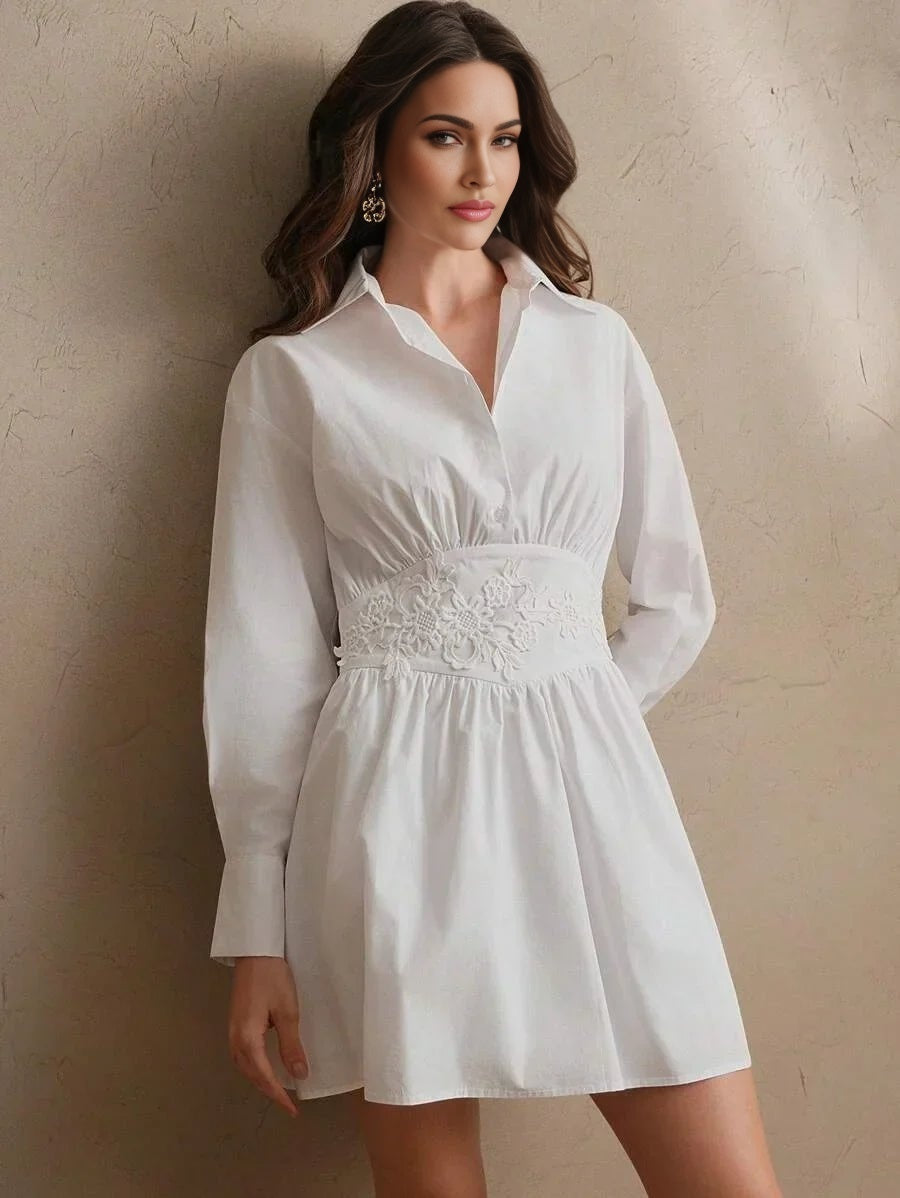 This charming white dress features a collared design with long sleeves, cinched at the waist with delicate floral embroidery.