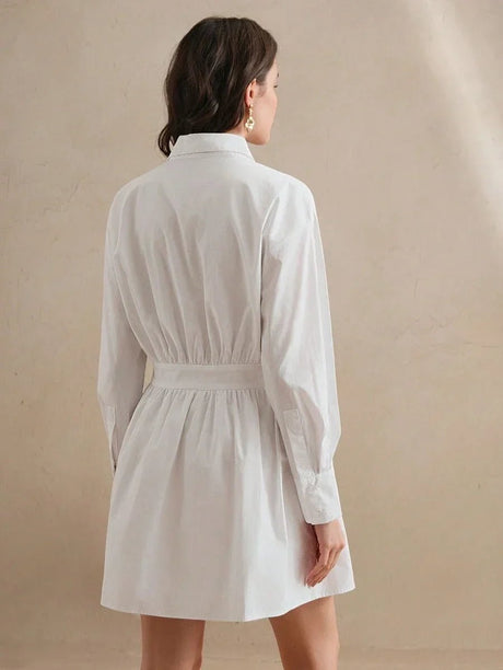 This elegant white shirt dress features a relaxed fit with stylish long balloon sleeves and a cinched waist for a flattering.