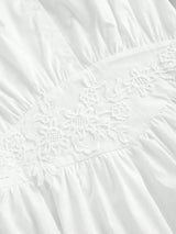 Charming and elegant, this white dress features delicate floral embroidery along the waistline, accentuating its soft,.