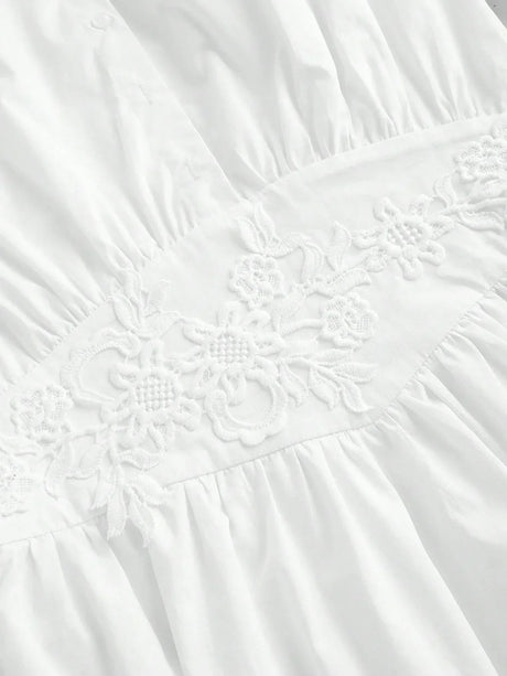 Charming and elegant, this white dress features delicate floral embroidery along the waistline, accentuating its soft,.