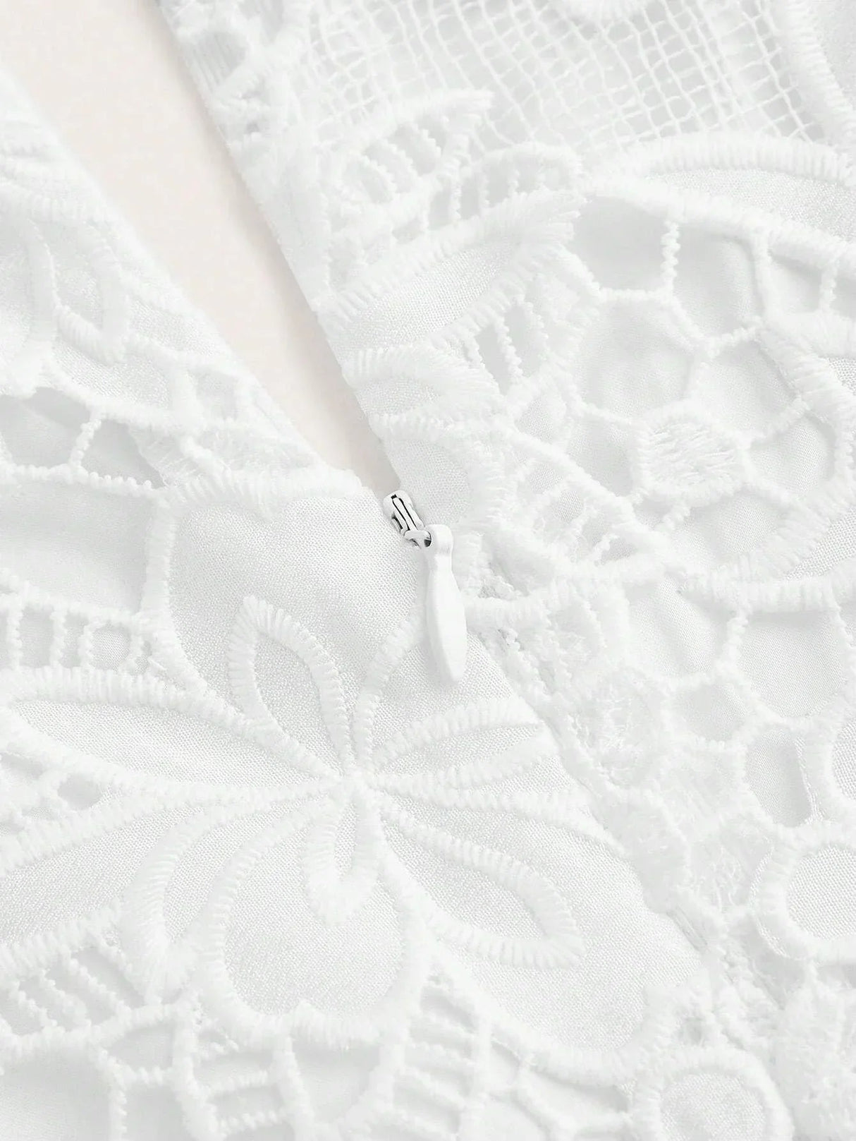 This elegant white dress features intricate floral lace detailing and a soft, flowing fabric that drapes beautifully..