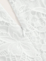 This elegant white dress features intricate floral lace detailing and a soft, flowing fabric that drapes beautifully..