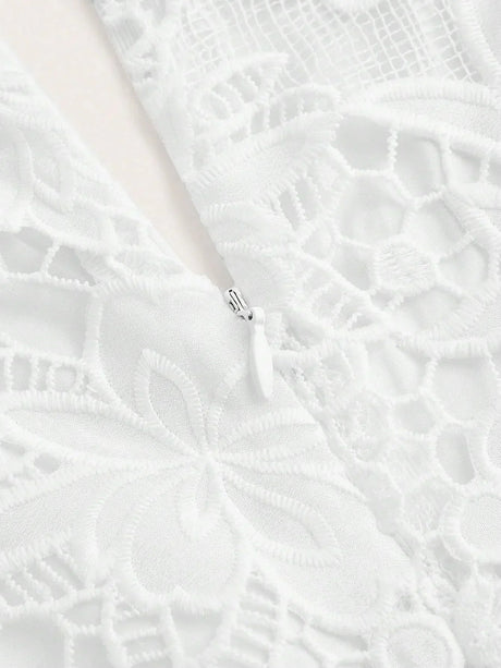 This elegant white dress features intricate floral lace detailing and a soft, flowing fabric that drapes beautifully..