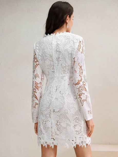 This elegant white lace dress features a fitted silhouette with long sleeves and intricate floral detailing, perfect for a.