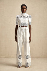 Matching set featuring a cropped top and trousers in white Raphaelle style with lace trim and cutout details