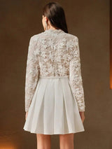 This elegant dress features a delicate sheer floral lace bodice in soft beige, beautifully complemented by a pleated white.