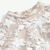 This elegant dress features a soft beige fabric adorned with intricate white floral embroidery, creating a stunning.