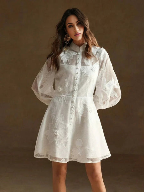 This charming white dress features delicate floral embroidery on a lightweight, sheer fabric, perfect for warm-weather.