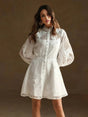 This charming white dress features delicate floral embroidery on a lightweight, sheer fabric, perfect for warm-weather.