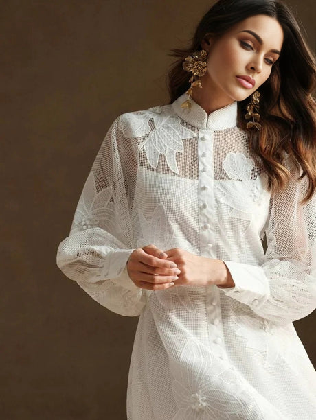 This elegant white dress showcases a delicate floral mesh overlay that offers a romantic, airy vibe. With a button-up front.