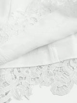 This elegant white dress features intricate floral lace detailing at the hem, adding a touch of sophistication to its.