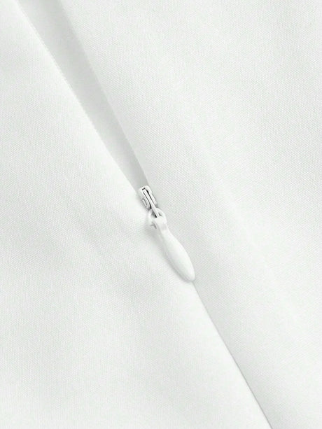 A close-up view of a crisp white dress featuring a hidden zipper, showcasing its sleek lines and minimalist design. The.