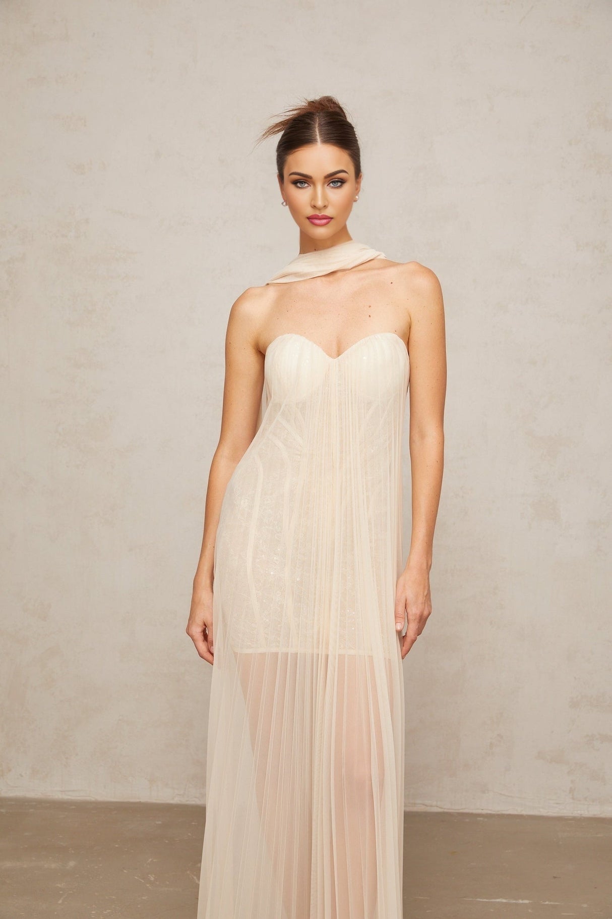 Neutral colored long tulle maxi dress with pleated skirt and ribbon design details