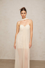 Neutral colored long tulle maxi dress with pleated skirt and ribbon design details