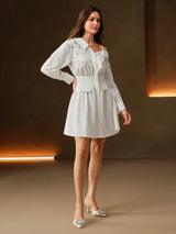 This elegant white dress features a fitted bodice with a chic off-the-shoulder design, complemented by long sleeves adorned.