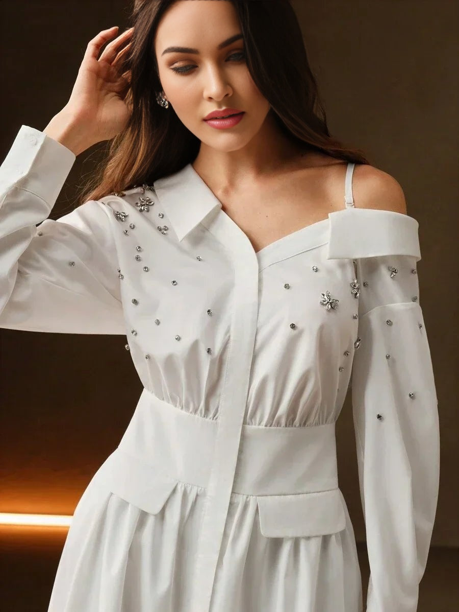 This elegant white dress features a sophisticated off-shoulder design adorned with shimmering embellishments, adding a touch.