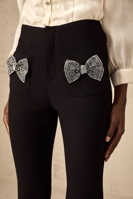 Pair of flared trousers with a bow embellishment on the waistline