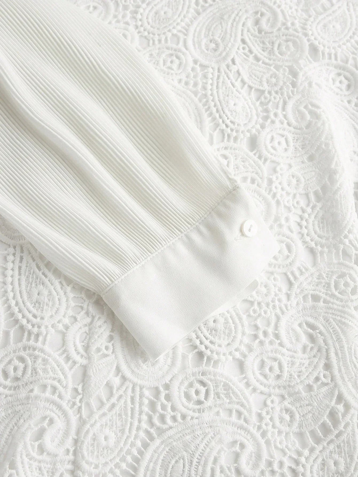 This elegant white dress features delicate pleated sleeves and intricate lace detailing that adds a touch of romance. The.