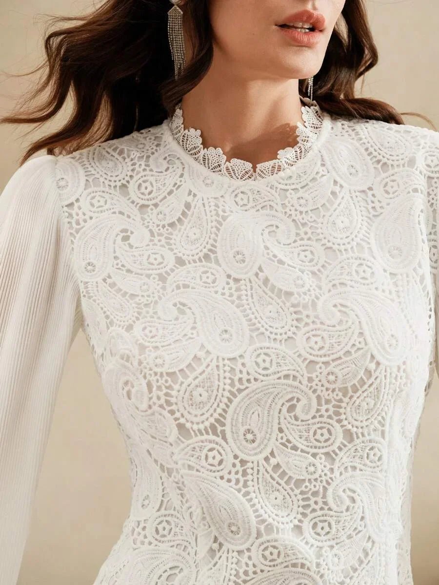 This elegant white dress features intricate lace detailing and a chic high neckline, showcasing a beautiful paisley pattern.