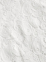 Delicate white lace fabric features an intricate paisley pattern, creating an elegant and airy look perfect for warm-weather.