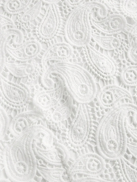 Delicate white lace fabric features an intricate paisley pattern, creating an elegant and airy look perfect for warm-weather.