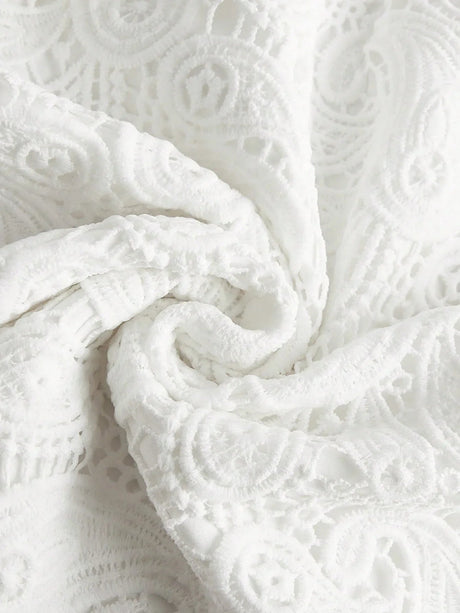 Delicate white lace dress featuring intricate embroidered patterns, exuding elegance and romance. Its soft, lightweight.