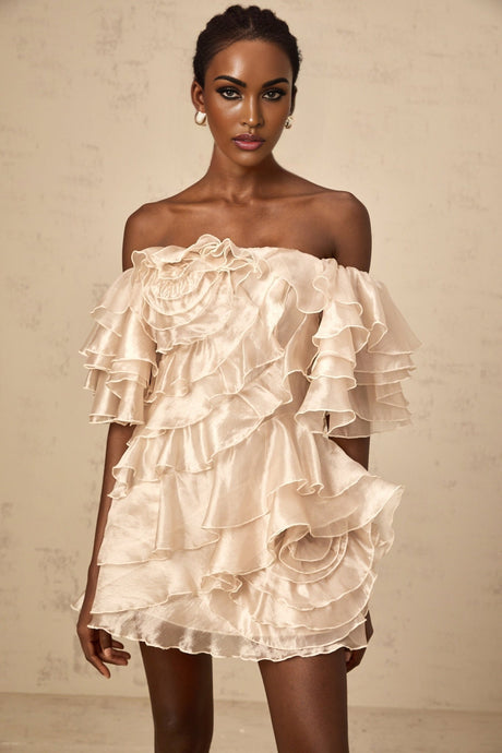Short flowy neutral colored dress with asymmetrical ruffled hem and one shoulder design