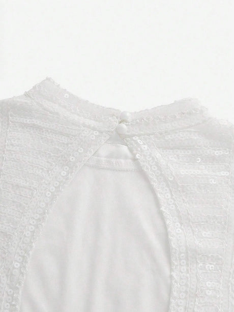 This elegant white dress features a delicate, sequined bodice that shimmers softly in the light, complemented by a smooth.