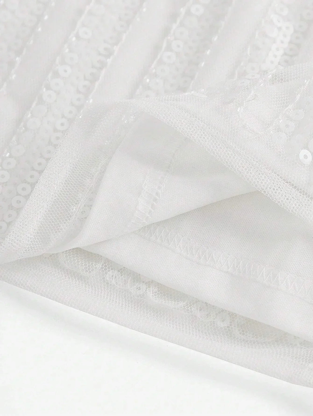 This elegant white dress features shimmering sequins and a flowing design that exudes sophistication. The lightweight fabric.