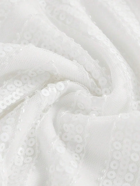 This elegant white dress features a sparkling sequined fabric that catches the light beautifully, giving it a stunningly.