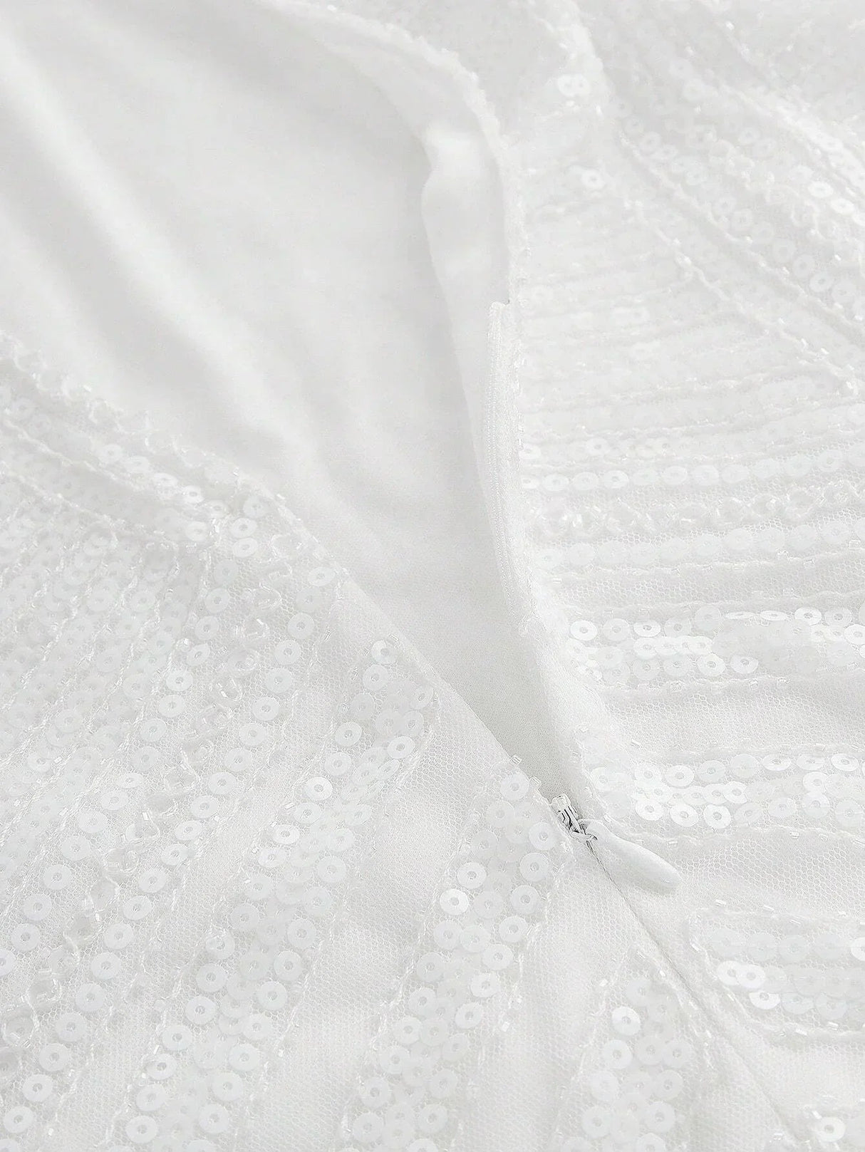 This elegant white dress features a shimmering sequin design that catches the light beautifully, offering a glamorous touch.