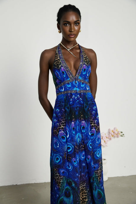 Sleek silk jumpsuit with halter neckline in deep blue color featuring wide leg pants and cinched waist