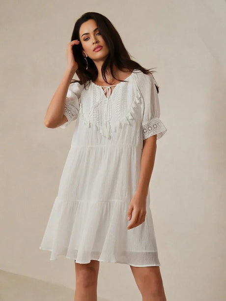 This elegant white dress features a charming tiered silhouette and delicate lace details, giving it a romantic, bohemian.