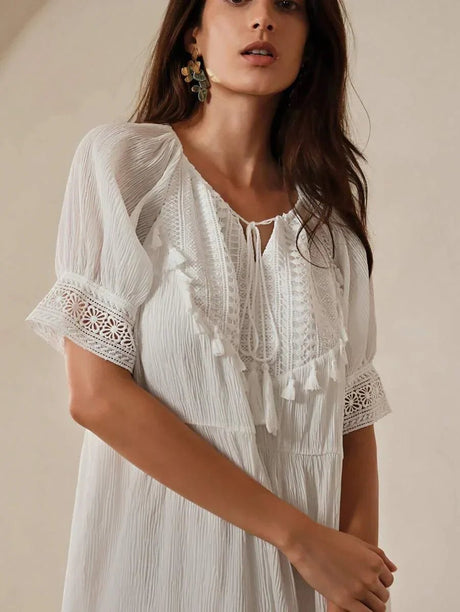 This elegant white dress features a flowing silhouette with delicate puff sleeves and intricate lace detailing. Crafted from.