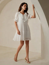 Experience effortless elegance with this charming white dress featuring a flowy silhouette and delicate short sleeves.