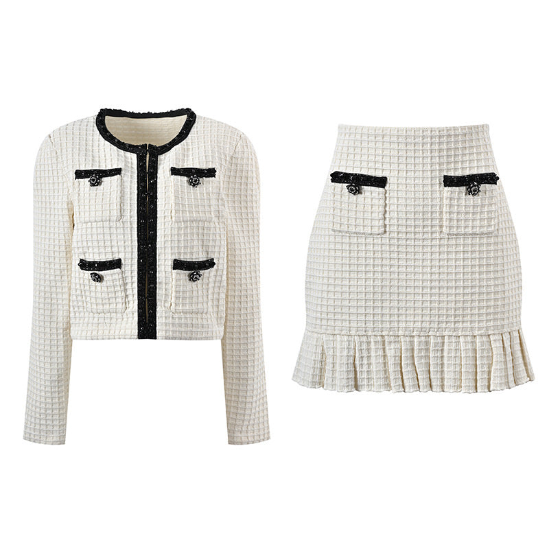 Textured white knitted jacket with black trim and decorative buttons paired with a ruffled hem skirt