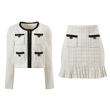 Textured white knitted jacket with black trim and decorative buttons paired with a ruffled hem skirt