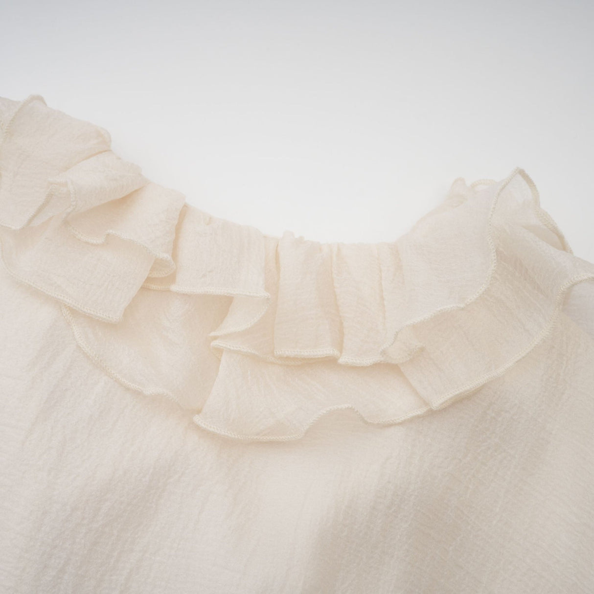 Tiered mini dress in neutral tones with floral applique detailing named Zephyrine