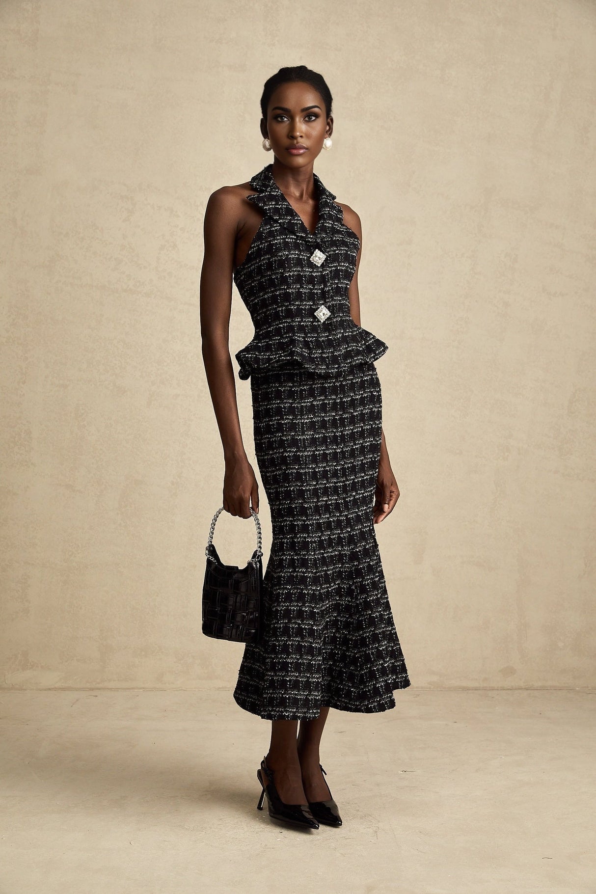 Two piece matching set featuring black and white checked tweed fabric consisting of a sleeveless vest top and a skirt