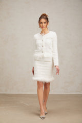 Two piece white waffle knit set featuring a feathered cardigan and matching skirt