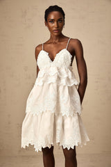 Valeria white mini dress with tiered skirt and guipure lace detailing shown on a model against a plain background