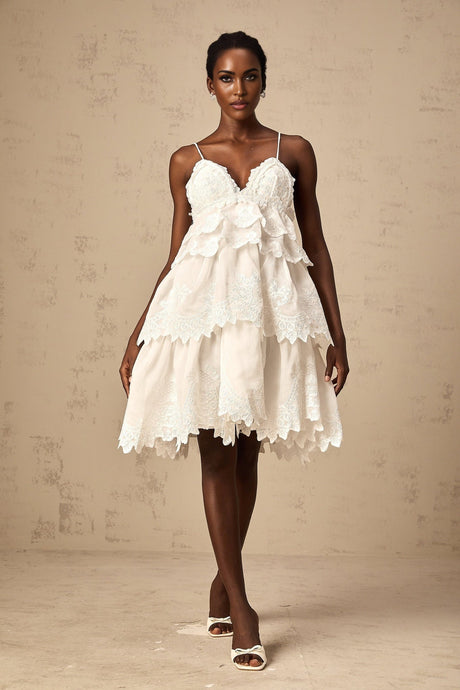 Valeria white tiered mini dress made of guipure lace shown on a model against a plain background