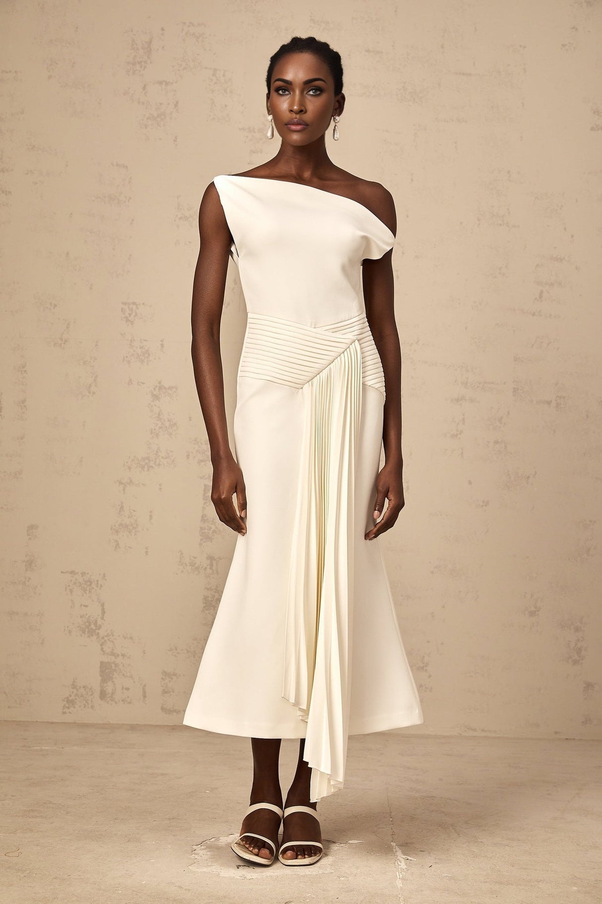 White asymmetric draped midi dress with flowing fabric and uneven hemline worn by model standing against plain background
