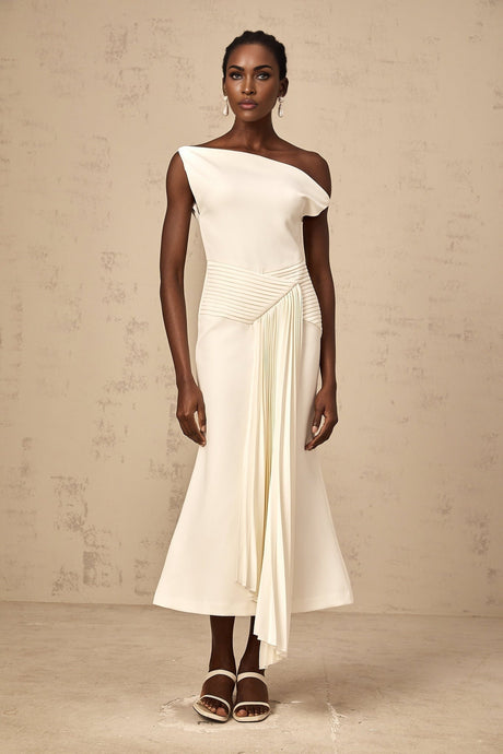 White asymmetric draped midi dress with flowing fabric and uneven hemline worn by model standing against plain background