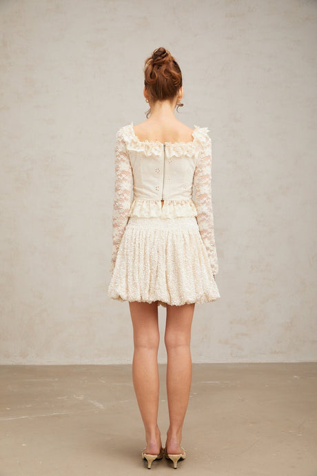 White lace blouse with floral pattern and ruffled details