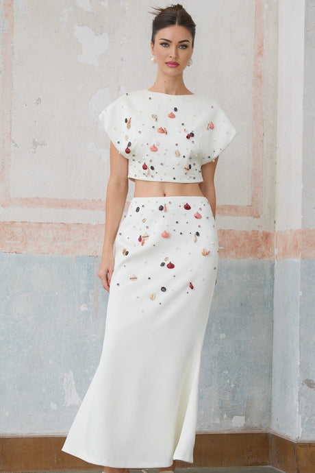 White matching set featuring a top and skirt adorned with shell embellishments named Delphine